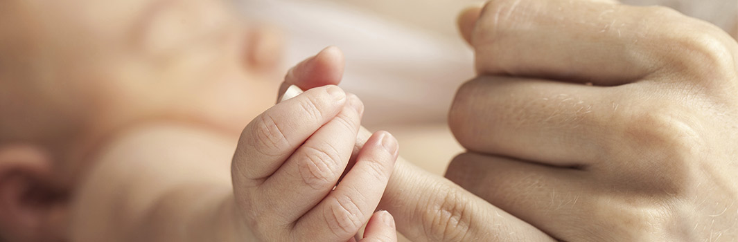 baby holding mothers finger